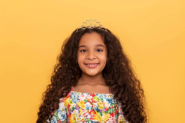 一个黑皮肤的年轻姑娘的半身肖像 她有一头长长的卷发 穿着黄色背景的艳丽连衣裙 — 图库照片