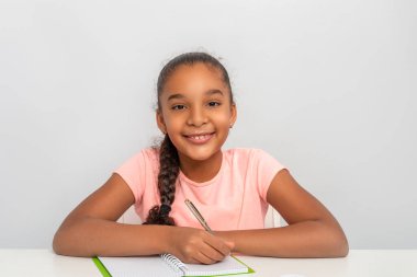 Liseli kız masaya oturur ve not defterine yazar. Eğitim kavramı