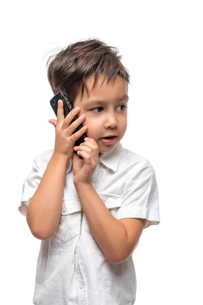 Студійний Знімок Маленького Хлопчика Білій Сорочці Емоційно Розмовляє Телефону Білому — стокове фото