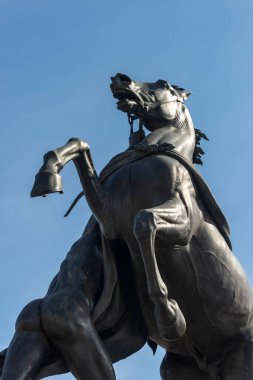 St. Petersburg 'daki Nevsky Prospect' te, Anichkov köprüsünde atı ehlileştiren ünlü bronz heykel atleti mavi gökyüzüne karşı.