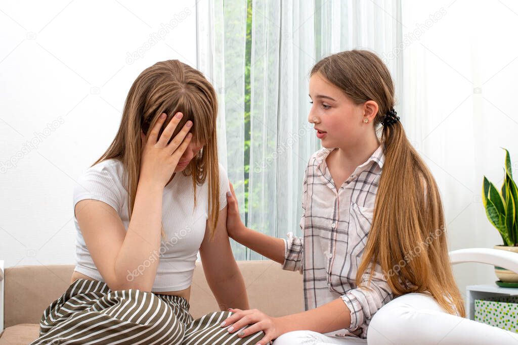 Shot of two girlfriends spending time together at home. One girl calms her friend upset about something. Relationship concept