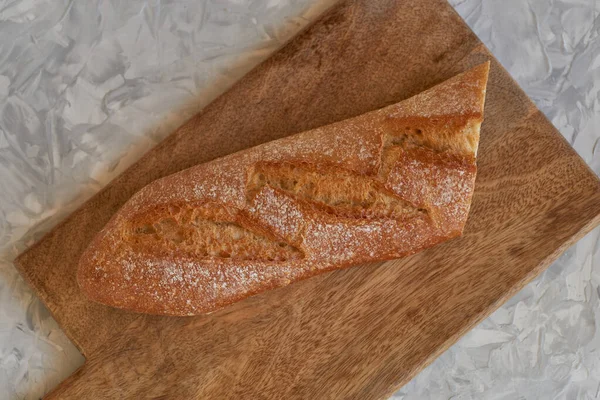 Masanın üstündeki tahtanın üzerinde yarım beyaz ekmek kapağı, üst manzara.