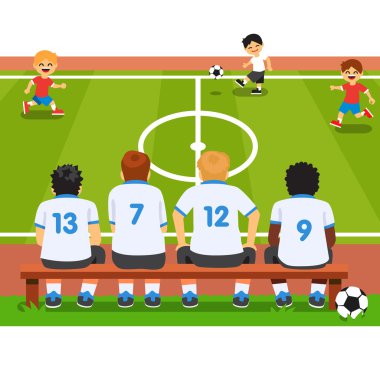Bir bankta oturan çocuk futbol takımı