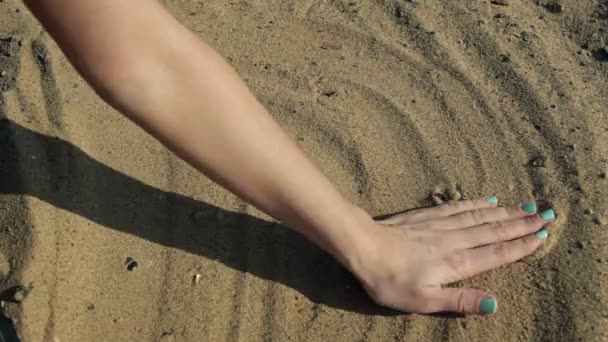 Menina desenha um coração nas mãos da areia — Vídeo de Stock