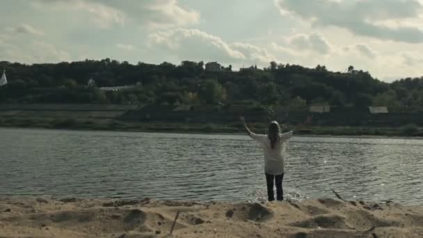 Ona běží do vody na písečné pláži — Stock video