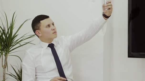 Businessman in a white shirt makes selfie — Stock Video