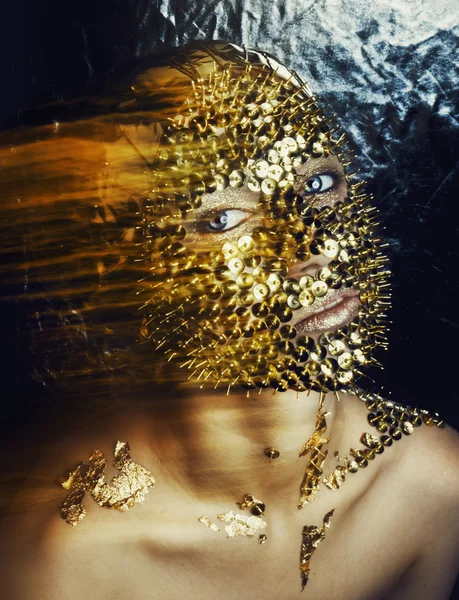Κορίτσι με χρυσό μόδας μακιγιάζ κουμπιά και φύλλα αλουμινίου στο πρόσωπό της — Φωτογραφία Αρχείου