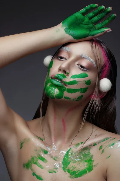 Schöne junge Frau mit sauberer frischer Haut rosa Make-up und Handabdruck mit grüner Farbe — Stockfoto