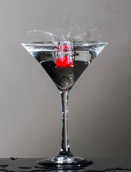 Cherry dropping into a martini