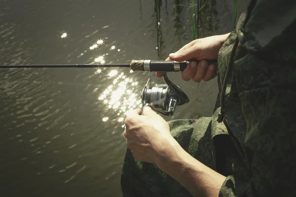 Pescador con caña de pescar en la orilla del río — Foto de Stock