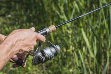 Nehir kıyısında elinde olta olan bir balıkçı.