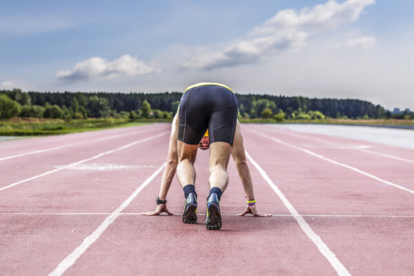 Professional male runner taking ready to start position