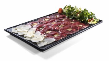Et carpaccio parmesan ve üzerinde beyaz izole salata ile