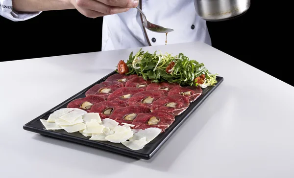 Carpaccio van vlees gekruid met olijfolie door chef — Stockfoto