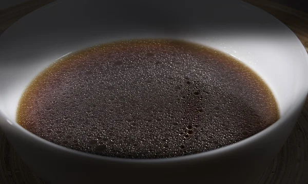 Bouillon de viande marron dans un bol blanc close-up — Photo