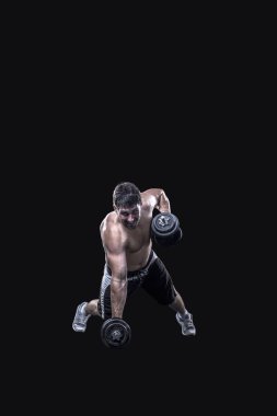Siyah arka plan üzerine izole dumbbells ile erkek atlet yapmak egzersiz
