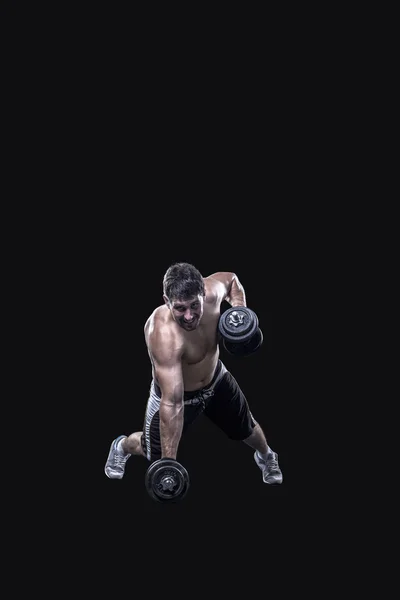 Athlète masculin faisant de l'exercice avec haltères isolé sur fond noir — Photo