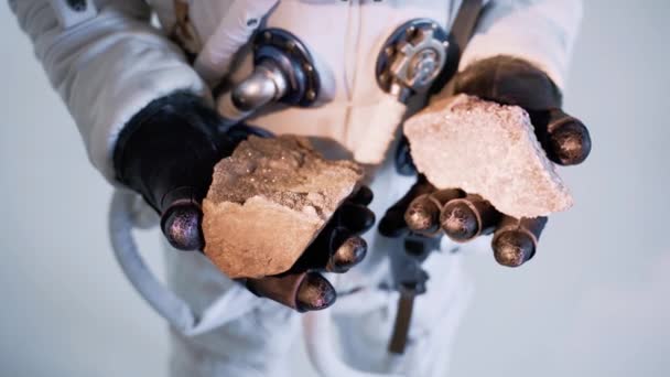 Astronot taşları tutuyor, mineraller beyaz arka planda. stüdyo — Stok video