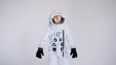 Astronot gülümsemesi ileri gider ve başparmaklarını kaldırır. stüdyo