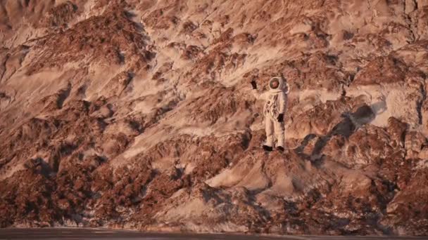 Astronaut în picioare pe o mână de rocă fluturând. descoperirea unei noi planete — Videoclip de stoc