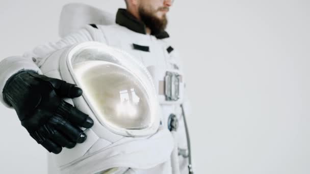 Astronaut s brýlemi a helmou v ruce na světlém pozadí. studio — Stock video