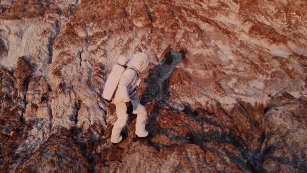 El astronauta sube la roca con dificultad y luego se detiene. fotografía aérea — Vídeos de Stock