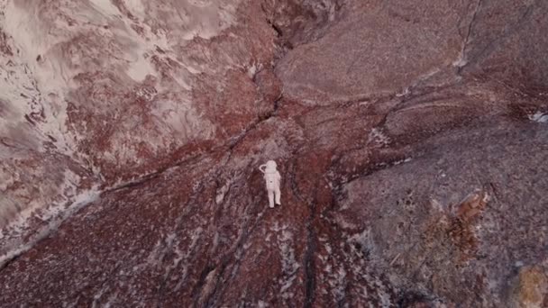 Astronauta idzie ostrożnie wzdłuż skały. zdjęcia lotnicze — Wideo stockowe