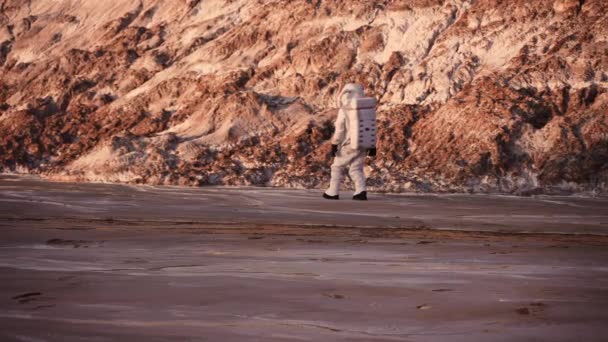 Astronaute marche prudemment au pied de la colline. découverte d'une nouvelle planète — Video