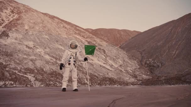 Astronauta pelas colinas com a bandeira fecha a partição do capacete — Vídeo de Stock