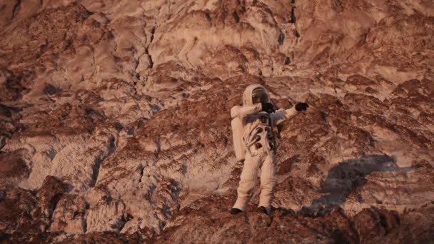 Astronauta bailando de pie sobre una roca.El sol está brillando. — Vídeos de Stock