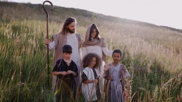 Jesús con cosas, niños y María entre las orejas en la colina. Sol brillando — Vídeo de stock