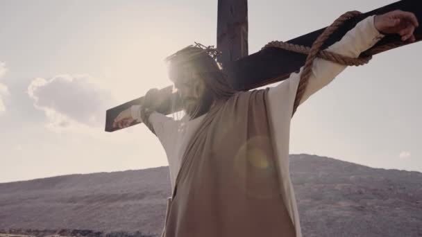 Jesús crucificado en la cruz, el viento sopla. El sol brilla. Corona de espinas. — Vídeo de stock