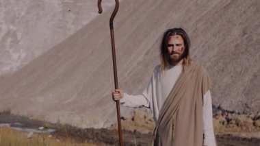 Hz. İsa cüppeli bir asayla dağda dikiliyor ve uzaklara bakıyor..