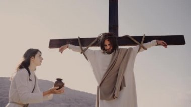 Meryem çarmıha gerilen İsa 'ya su verir. Dikenli taç. Güneş parlıyor.