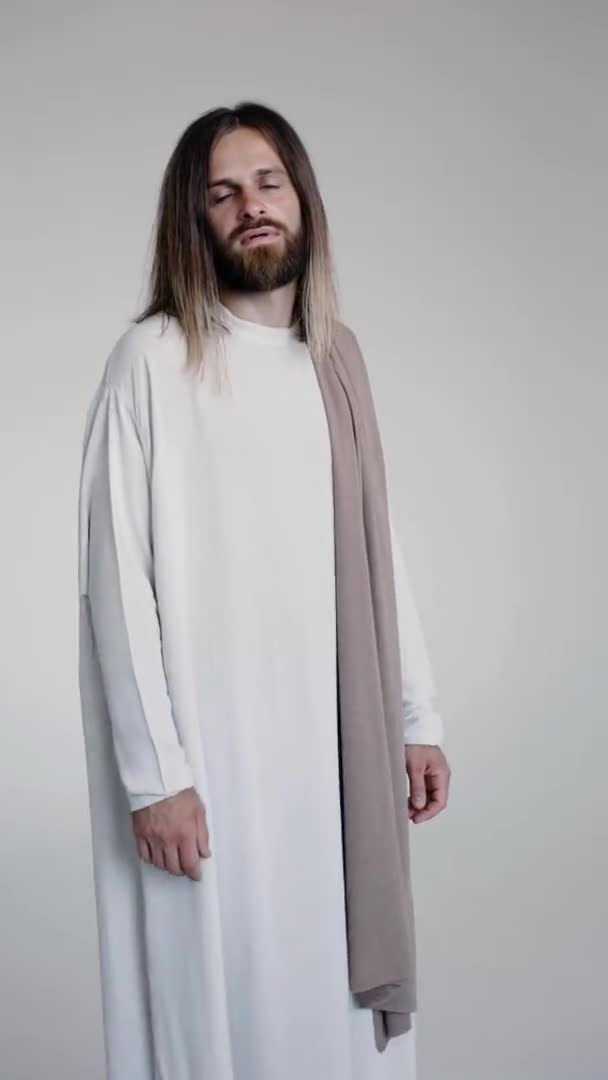 Jesus stretches out his hand leads behind him on a white background. Studio. — Stock Video