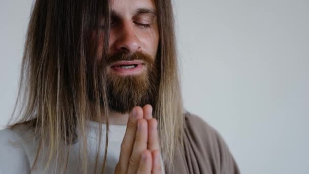 イエスは白い背景で手を合わせて祈ります。スタジオだ。閉じろ!. — ストック動画