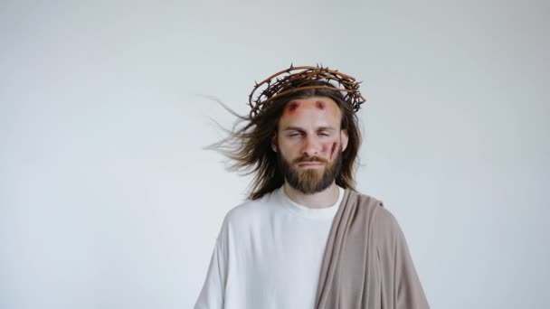 Yüzünde yaralar olan dikenli bir taç içindeki İsa kameraya bakar.. — Stok video