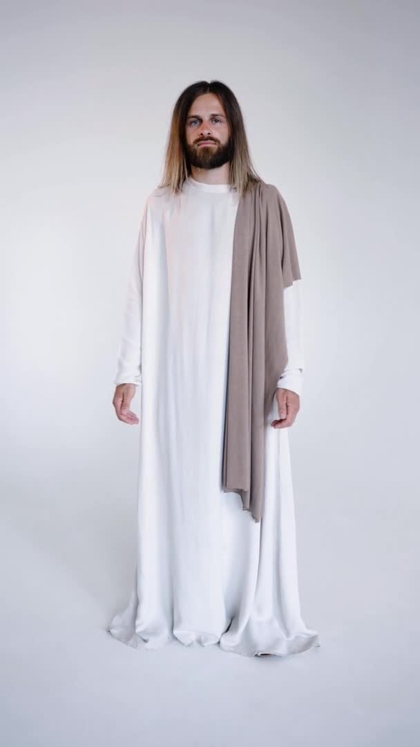 Jesus in robe spreads his hands to the sides calling for prayer.Studio. Vertical — Stock Video