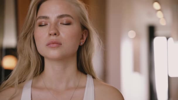 Die junge blonde Frau meditiert mit geschlossenen Augen. Morgenyoga. — Stockvideo