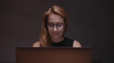 Evindeki bir kadın laptopta çalışıyor, görüntülü konuşma yapıyor. COVID-19