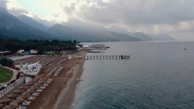 Gün batımında deniz kıyısında. Dağın arka planı. Yukarıdan görüntüle.