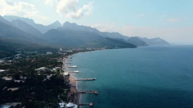 Gün batımında deniz kıyısında. Dağın arka planı. Yukarıdan görüntüle.