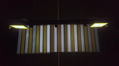 Gece boyunca boş yaya geçidine tepeden bakan drone görüntüsü. Bazen arabalar geçer. Trafik ışıkları yanıp sönüyor ve yol işaretleri yanıyor..