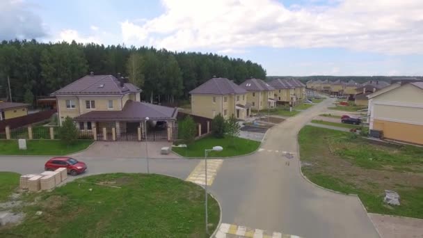 Aerial drone footage over the summer street. Modern luxury houses. Aerial flying over the residential area. Asphalt roads and sidewalks. Near the other village. Cloudy summer day — Stock Footage Aerial Drone Footage Summer Street Modern Luxury Houses Aerial Flying Royalty Free Stock Video
