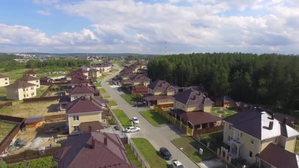 Aerial drone footage over the summer street. Modern luxury houses. Aerial flying over the residential area. Asphalt roads and sidewalks. Near the other village.Sunny summer day — Stock Footage Aerial Drone Footage Summer Street Modern Luxury Houses Aerial Flying Royalty Free Stock Footage