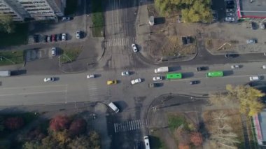 Şehir trafiği kavşağın aşağısında. Sonbahar güneşli bir gün. Ağaçlardaki yapraklar kırmızı ve sarıya döner. Kamera yükseliyor.