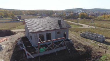 İnşaat alanının etrafında köpük bloklardan yapılmamış modern enerji verimliliği olan metal kiremit kaplamalı panellerle uçuyor.