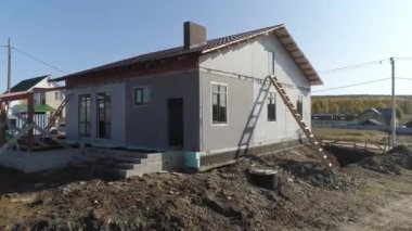 Tamamlanmamış modern enerji verimliliği olan köpük bloklama panelleri ve metal kiremit kaplamalı çatısı olan inşaat alanı. Köydeki ev. Güneşli bir gün