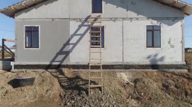 Tamamlanmamış modern enerji verimliliği olan köpük bloklu evlerin metal kaplamalı çatılarının havadan görünüşü. Köydeki ev. Güneşli bir gün