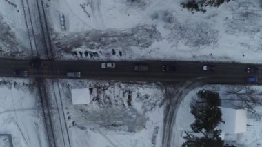 Demiryolu geçidinden geçen arabaların yukarıdan aşağıya bakan görüntüsü.